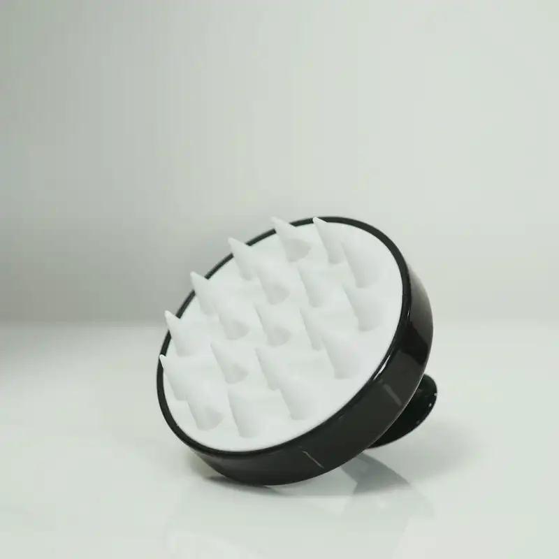 白いシリコンの毛がついた頭皮用のブラシ